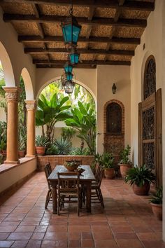 an outdoor dining area with potted plants on the side and large arched doorways