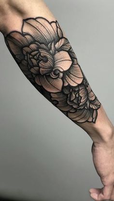 a black and white flower tattoo on the arm