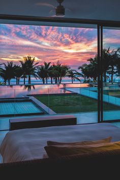 a bed sitting next to a large window overlooking a swimming pool