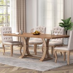 a dining room table with chairs and a bowl of fruit on top of the table