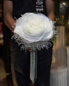 a person holding a white flower in their hand