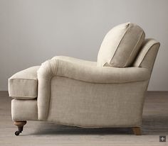 a white chair sitting on top of a hard wood floor next to a gray wall