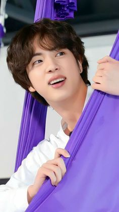 a young man in white shirt and purple hammock