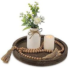 a wooden tray with candles and flowers on it