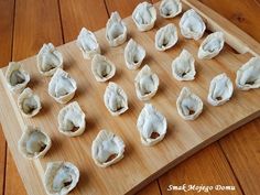 an assortment of dumplings on a cutting board ready to be cooked in the oven