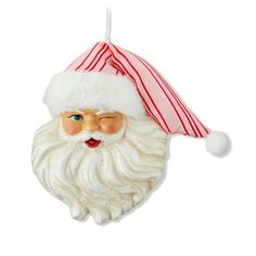 a santa claus ornament hanging on a white wall