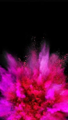 a red and pink powder explosion in the dark