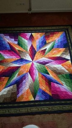 a colorful quilt is hanging on the wall