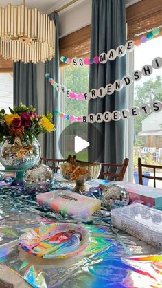 the table is covered with many items and has flowers in glass vases on it