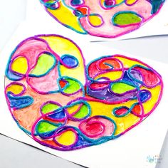 two heart shaped paintings are shown on paper