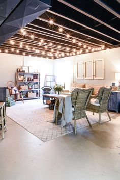 a living room filled with furniture and lots of lights hanging from the ceiling above it