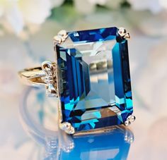 an emerald - cut blue topazte ring sits on a table