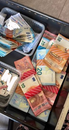 there are many different types of money in the trays on this table, including ten thousand euros