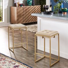 two stools sitting on top of a wooden floor in front of a kitchen counter