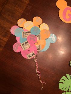 a wooden table topped with lots of paper cut outs and money on top of it