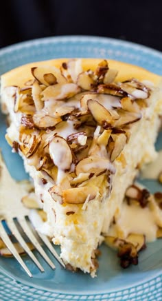 a blue plate topped with a slice of cake covered in frosting and toppings