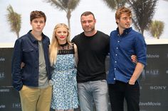 three men and a woman standing next to each other in front of a movie poster