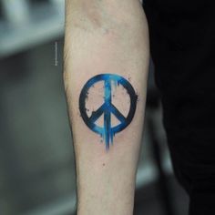 a blue peace sign tattoo on the arm