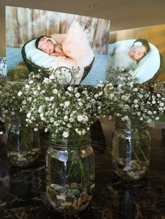 three mason jars with baby's breath in them on a table next to flowers