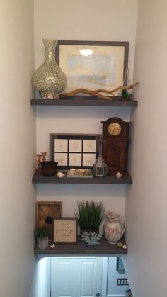 three shelves with various items on them in a corner next to a wall mounted clock