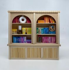 two bookshelves with different types of books on top of each shelf and one has a roll of toilet paper in the middle