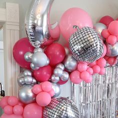 a bunch of balloons that are hanging on the wall in front of a mirror frame