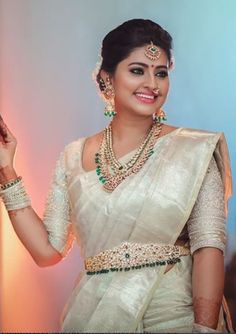 a woman in a white sari and jewelry