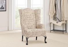 a chair with writing on it sitting in front of a white wall and two windows