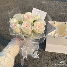 a bouquet of white roses in a box and gloves