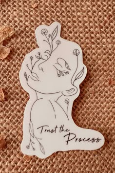 a white sticker with the words trust the princess on it sitting next to some dried leaves