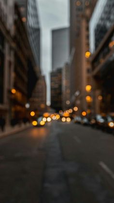 an empty city street at night with buildings in the background