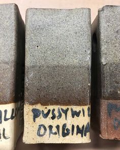 three cement blocks with writing on them sitting side by side in front of each other