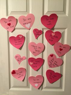 a door decorated with pink paper hearts and writing on them