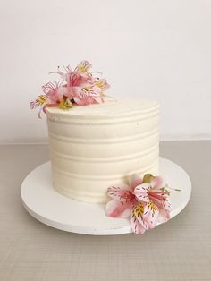 a white cake with pink flowers on top