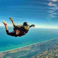 a man flying through the air while wearing a helmet and holding on to his feet