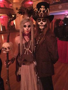 two people are dressed up as skeletons and skeleton headdresses at a halloween party