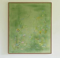 a painting hanging on the wall with water lillies and grass in front of it