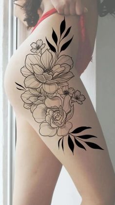 a woman's thigh with flowers and leaves on the back of her leg,