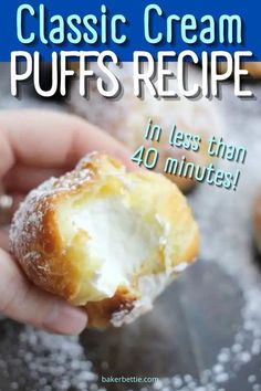 a close up of a person holding a doughnut with powdered sugar on it