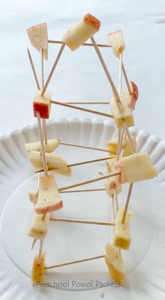 a white plate topped with fruit and toothpicks