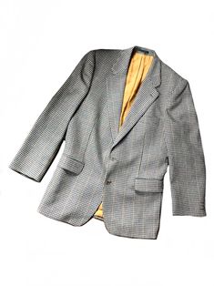 a  large brown tweed hacking jacket by Magee the blazer is made of pure wool tweed with a hounds tooth  weave pattern in dark green on a beige background with a dark yellow and red thread. this beautifully tailored suit features a pointy lapel, two brown front buttons, two large front pockets, one breast pocket, shoulder pads. two inside pockets. three smaller buttons at each cuff. jacket is lined with beautiful gold orange viscose fabric.  Label :Magee label : made in Ireland Perfect for any oc Notch Lapel Tweed Jacket With Houndstooth Pattern, Tweed Houndstooth Blazer With Notch Lapel, Wool Houndstooth Long Sleeve Blazer, Semi-formal Wool Sport Coat With Houndstooth Pattern, Tailored Houndstooth Blazer With Notch Lapel, Classic Houndstooth Suits For Winter, Wool Sport Coat With Houndstooth Pattern For Semi-formal, Classic Winter Houndstooth Suit, Classic Wool Sport Coat With Houndstooth Pattern