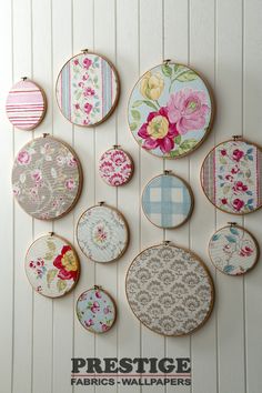 the wall is decorated with different types of embroiderys and flowers on fabric hoop holders