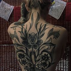 the back of a woman's body with tattoos on it