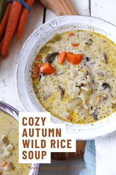 a white bowl filled with soup next to carrots