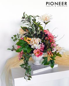 a vase filled with lots of flowers on top of a table