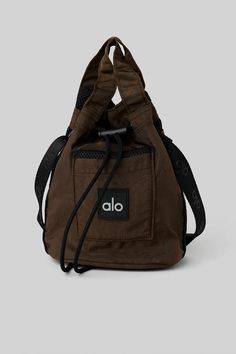 Cross Body Bucket Bag - Espresso/Black | Alo Yoga Functional Bucket Bag For On-the-go, Everyday Utility Bag With Removable Pouch, Functional Daily Use Bucket Bag, Functional Black Bucket Bag, Functional Bucket Bag With Adjustable Strap, Functional Pouch Bucket Bag For Travel, Functional Pouch-style Bucket Bag For Travel, Functional Bucket Bag For Travel, Functional Large Capacity Bucket Bag For Daily Use