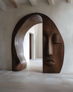 a large wooden sculpture sitting in the middle of a room next to an open doorway