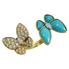 This dazzling Between the Finger ring from Van Cleef & Arpel's Two Butterfly collection is made in 18k yellow gold and features a pair of butterflies fitting perfectly between two fingers in a striking contrast of 36 D-E-F VVS1-VVS brilliant-cut round diamonds weighing an estimated 1.0 carat and 4 vivid blue turquoise stones. Made in France circa 2020s. Measurements: 1.41" (36mm) width, 0.78" (20mm) length. The ring size is 4.75 - EU 48. Resizable at VCA. Sizing fees will be provided upon reques