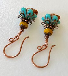 "Adorable new Czech glass premium flower earrings in turquoise and orange opaline with mustard yellow and copper accents. Opaque turquoise Czech glass flower caps with copper Picasso finish are accented with mustard yellow Picasso rondelles on top and dangling at the bottom are darling little Czech glass lily flowers in orange opaline with metallic copper wash. Colorful Czech flowers are wire wrapped in bright copper with antique copper accents. They hang from handmade German copper ear wires. T Unique Turquoise Czech Glass Earrings, Nickel Free Yellow Czech Glass Earrings, Unique Turquoise Earrings With Czech Glass, Nickel-free Yellow Czech Glass Earrings, Handmade Turquoise Flower-shaped Earrings, Turquoise Czech Glass Flower Earrings For Gift, Artisan Turquoise Czech Glass Earrings, Adjustable Turquoise Flower Earrings Gift, Turquoise Flower Earrings Gift