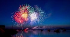 fireworks are lit up in the night sky over water